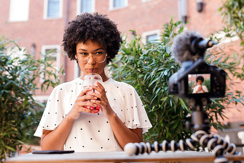 Girl drinking juice while making content for video blog