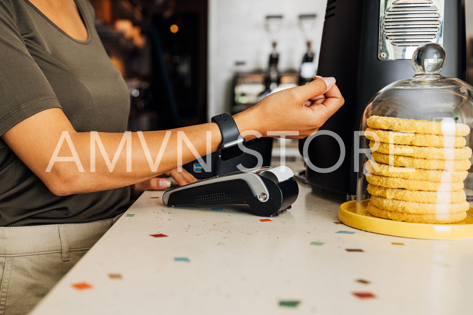 Mid section of unrecognizable customer paying contactless with her smart watch	