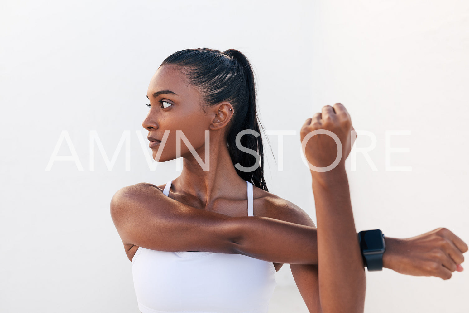 Young woman flexing her hands and looking away. Female stretching and warming up her hands before a workout.