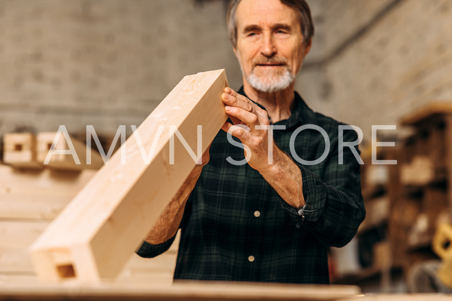 Senior carpenter checking a block of wood indoors	