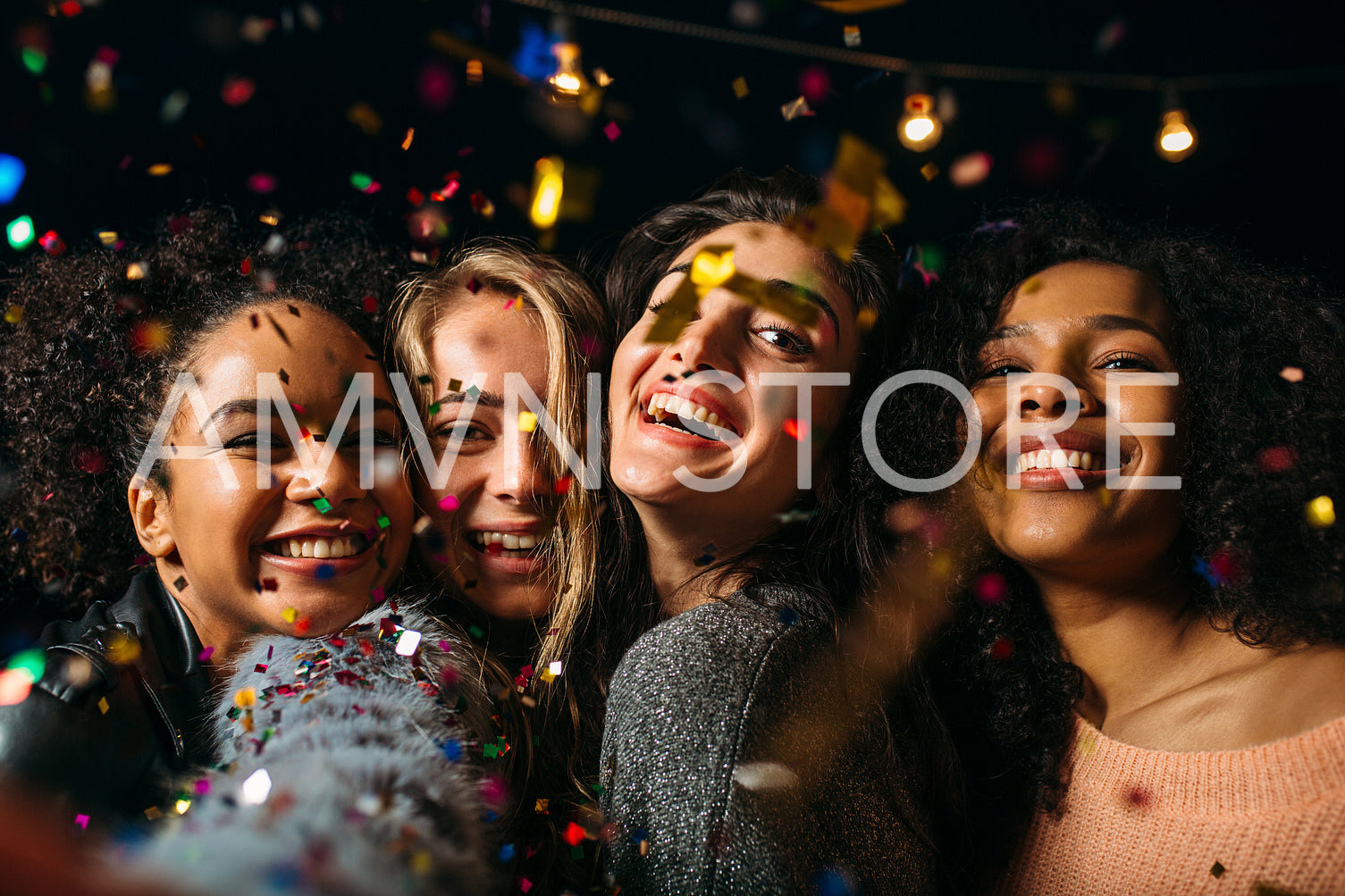 Four happy females taking selfie under colorful confetti