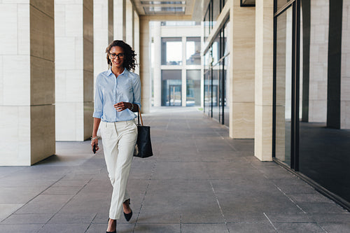 Woman walking from office with bag bag on her hand