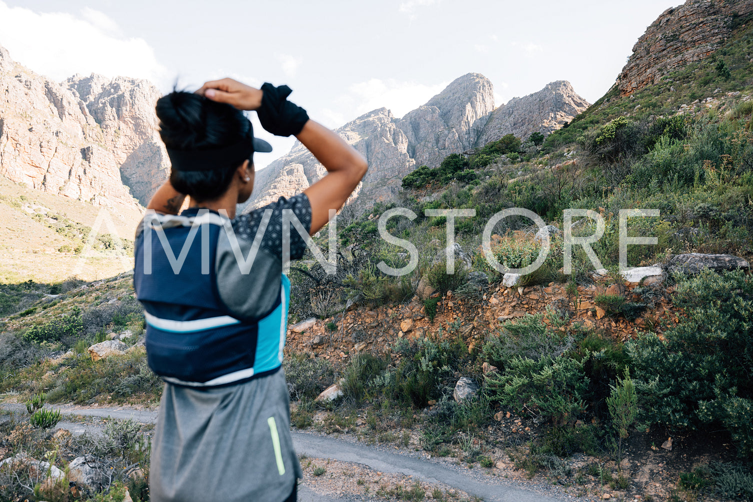 Back view of woman hiker looking in valley and enjoying the view, focus on mountains