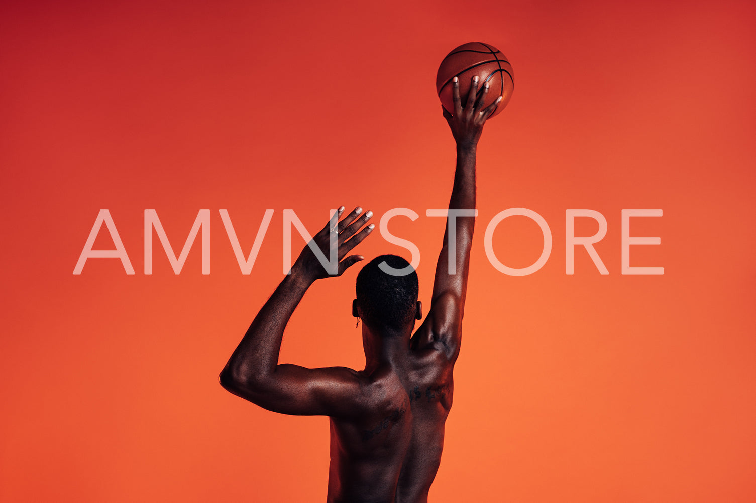 Back view of unrecognizable African American male athlete throwing basket ball against an orange background