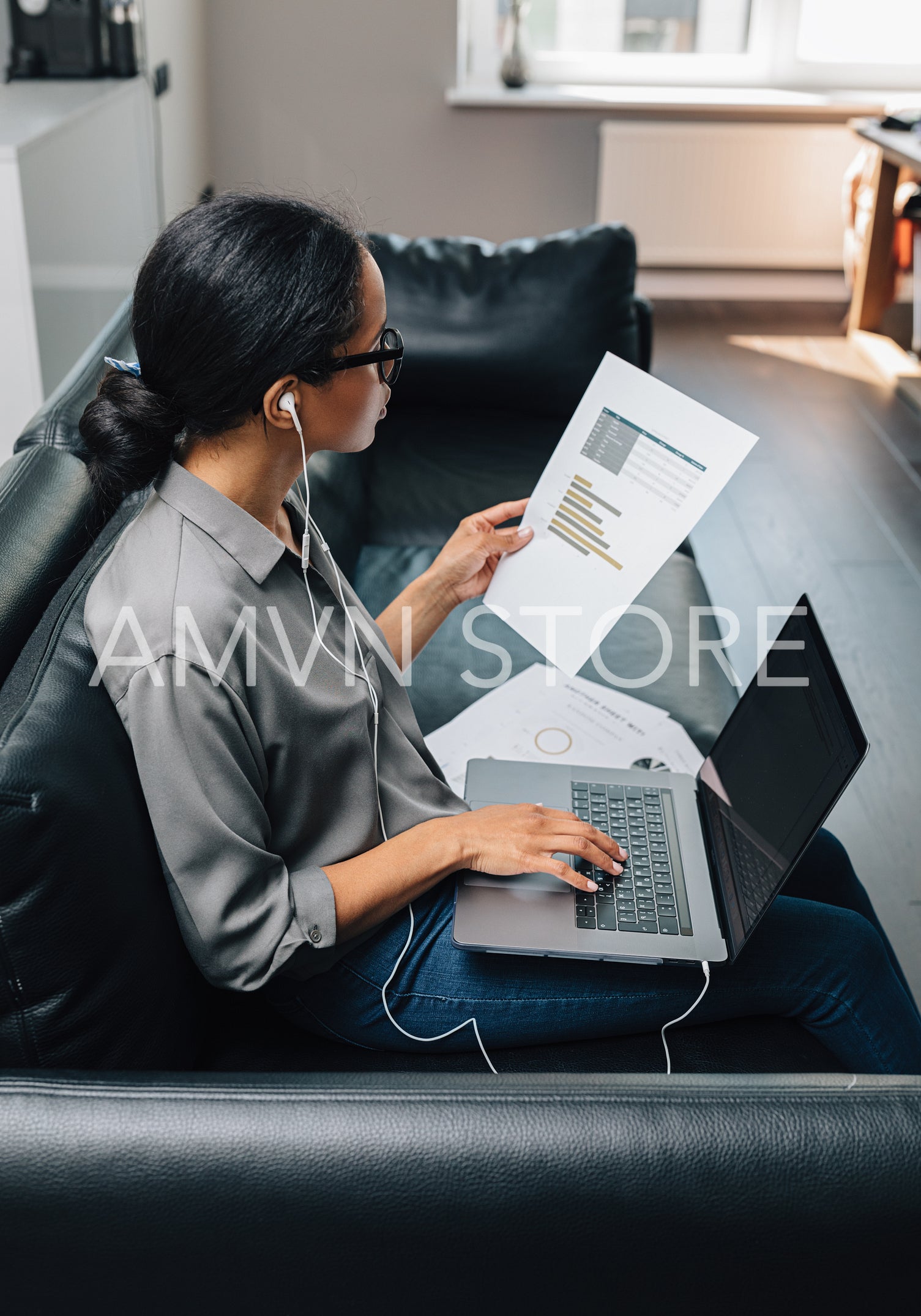 Businesswoman looking at documents in her apartment. Young freelancer working from home.	