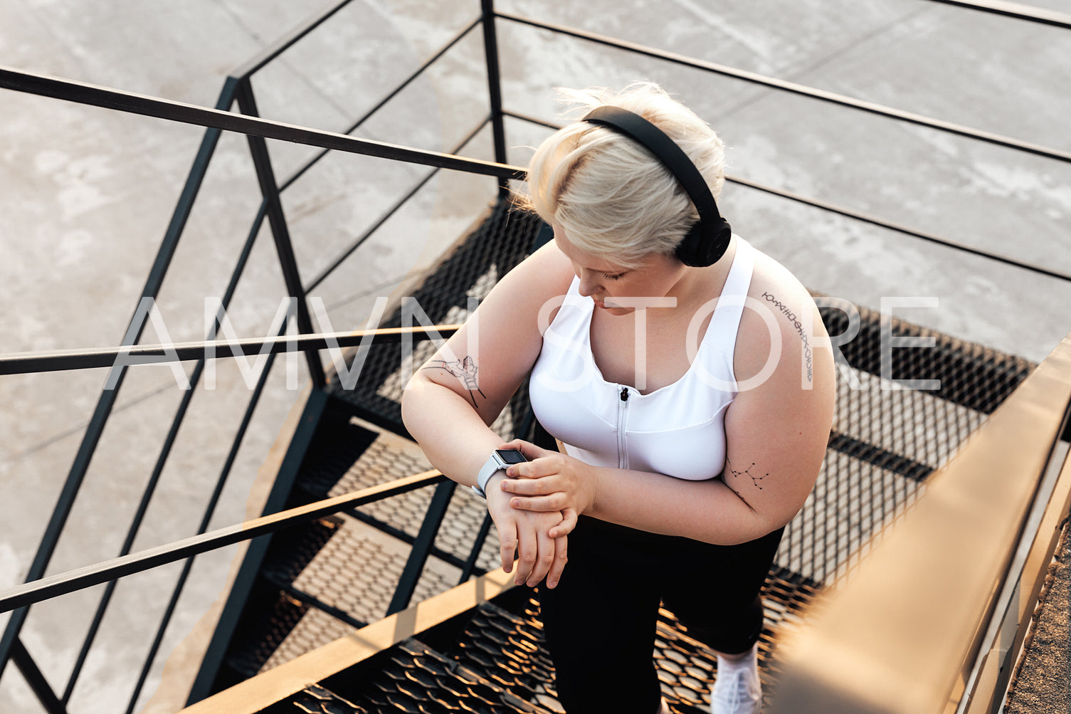 Hight angle view of a curvy woman stepping up on stairs checking pulse