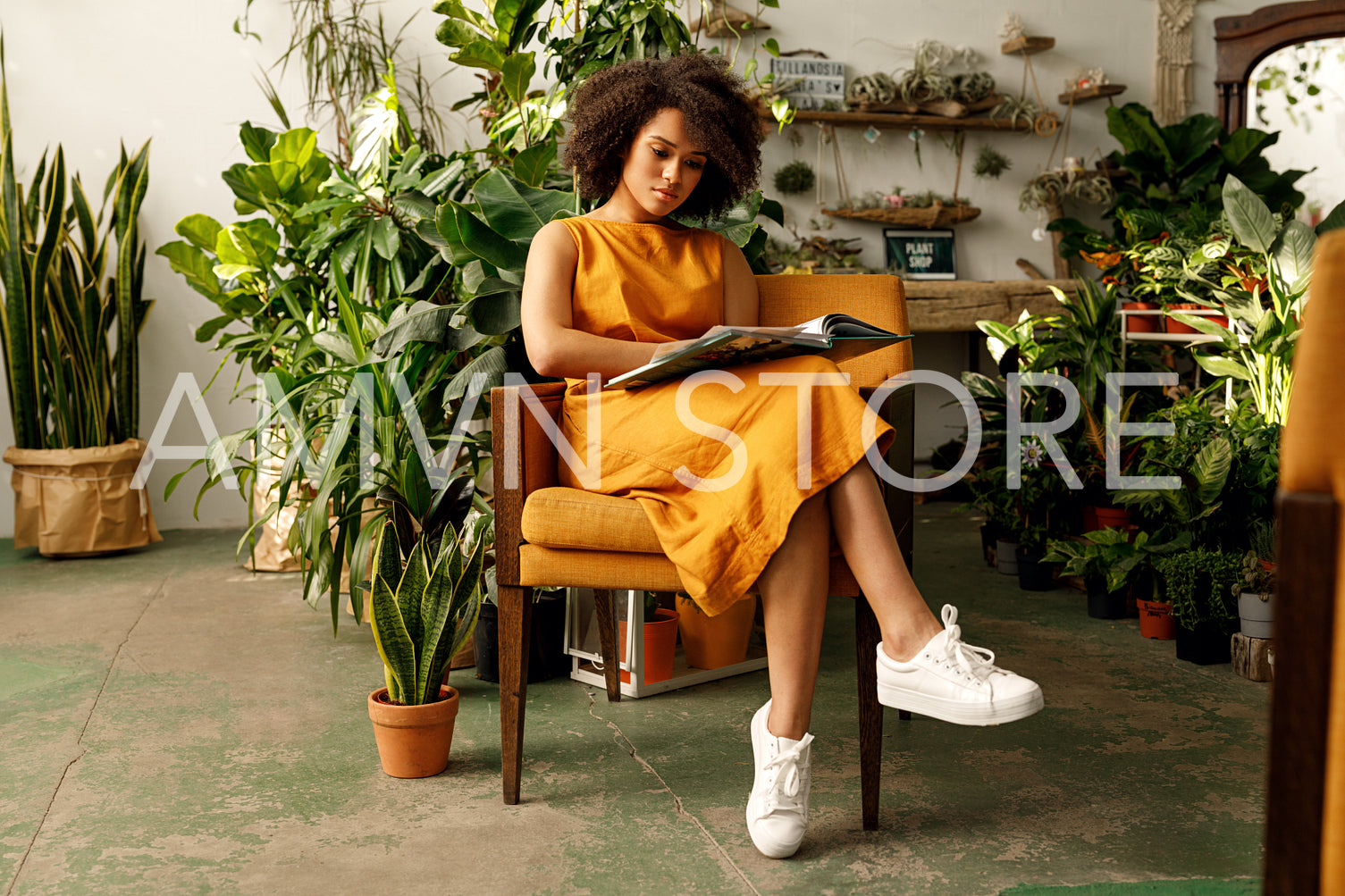 Woman botanist working at her indoor garden sitting on an armchair