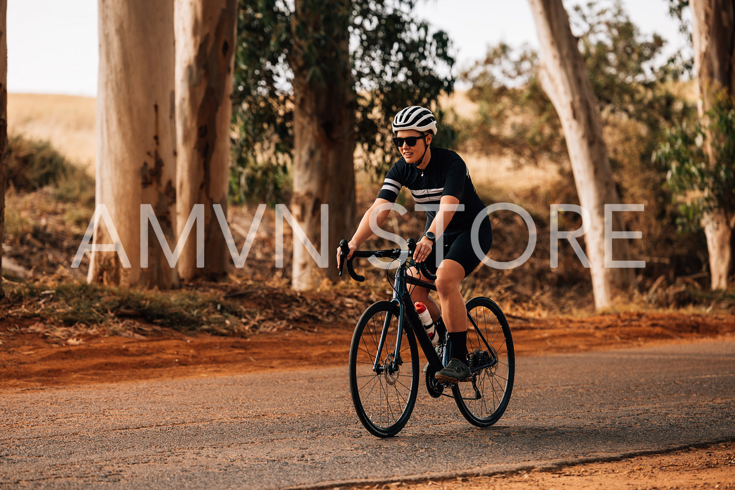 Professional cyclist in sportswear riding her bike on countryside road