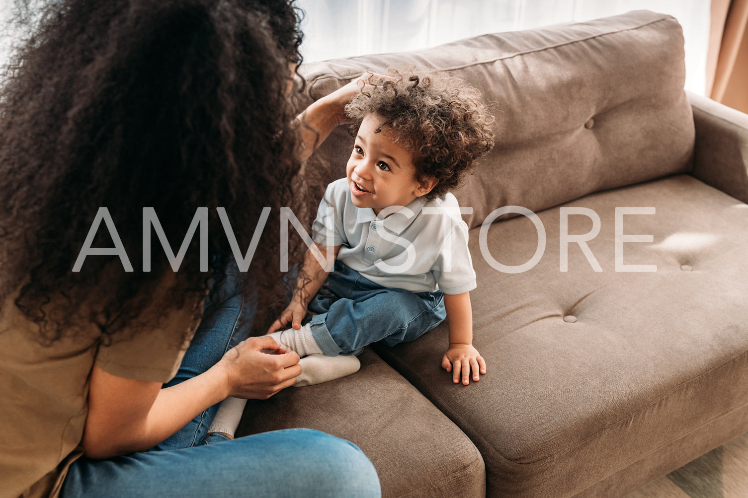 Little boy looking at her mother while sitting on a sofa