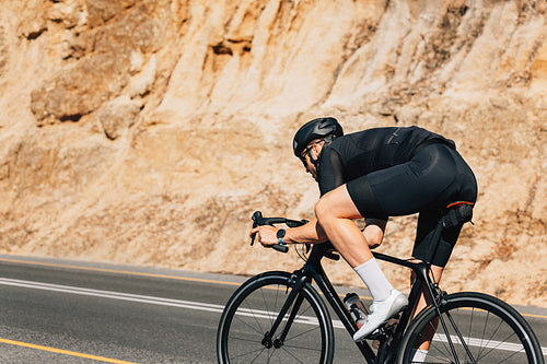 Male cyclist on his road bike. Professional bicycle rider practicing at sunny day.