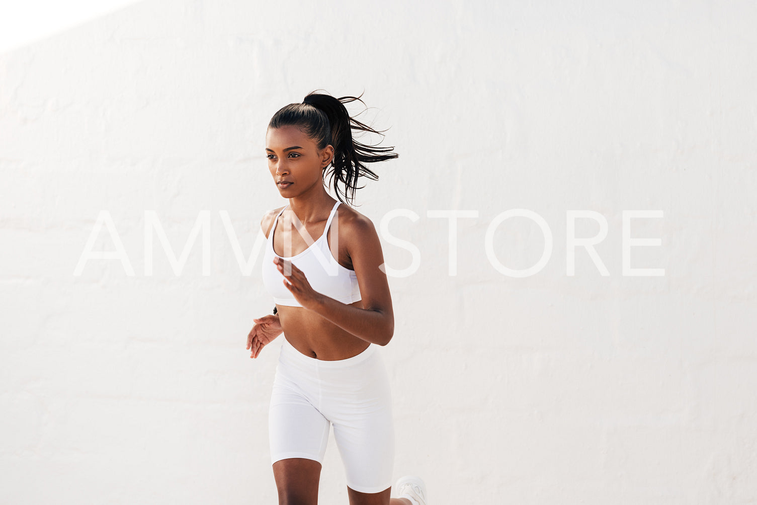 Slim woman in white fitness others running outdoors. Young slim fitness influencer jogging outdoors.