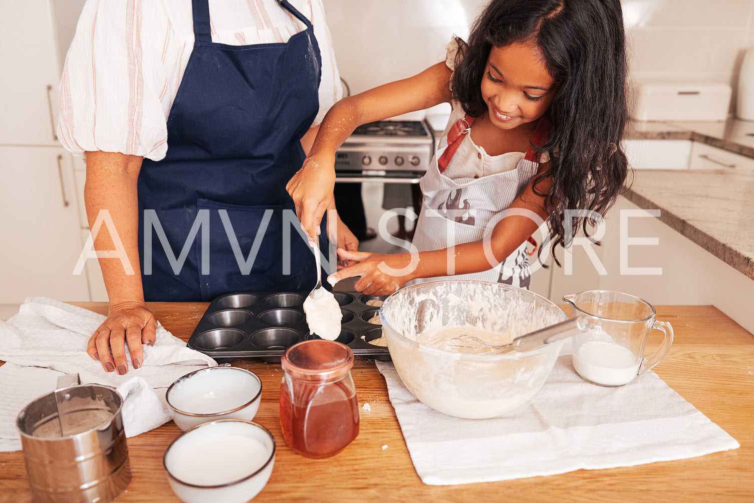 Girl using a spoon for pouring batter into molds