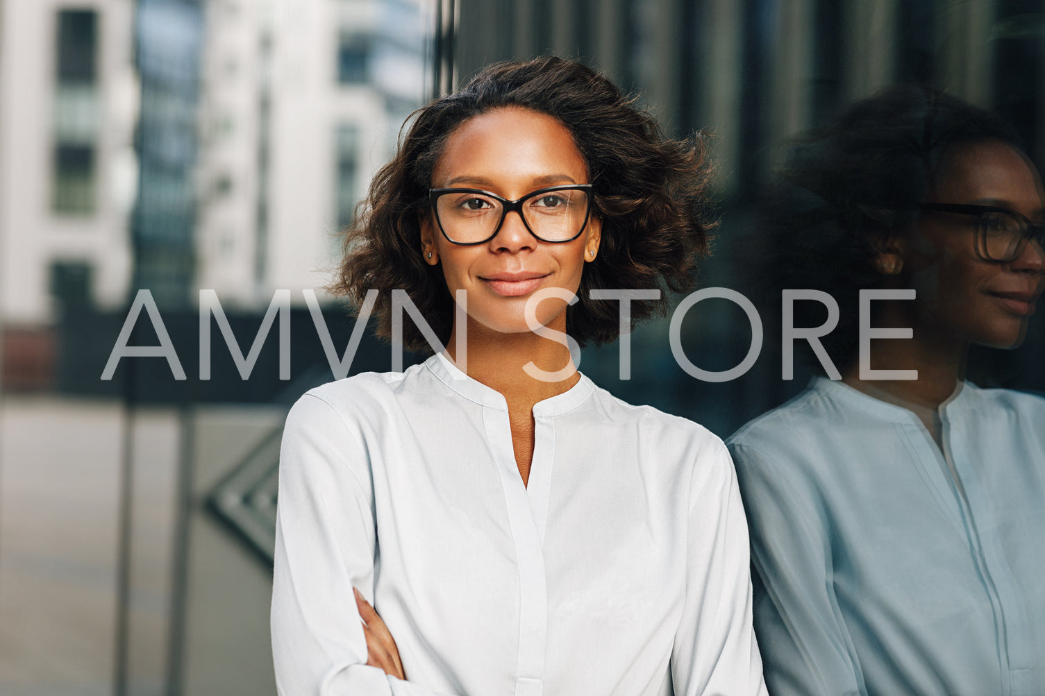 Portrait of a beautiful businesswoman in glasses standing outdoors and looking away. Young entrepreneur near office building.	