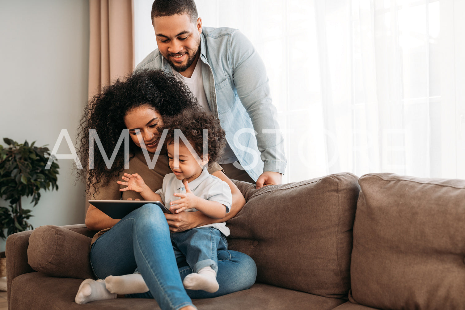 Happy family using digital tablet. Young parents looking how their son learning