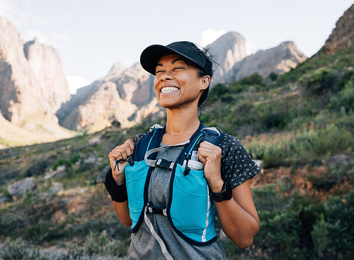 Happy female hiker in sportswear standing in valley with closed eyes