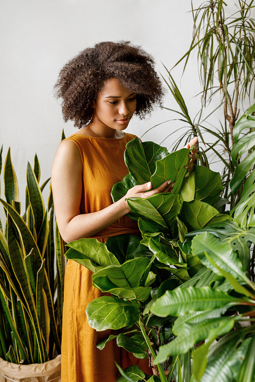 Beautiful woman botanist working at her indoor garden