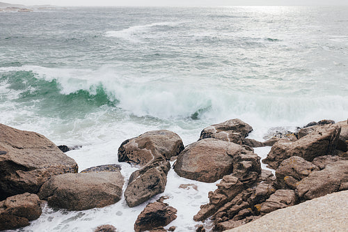 Oceanside with a lot of stones and waves