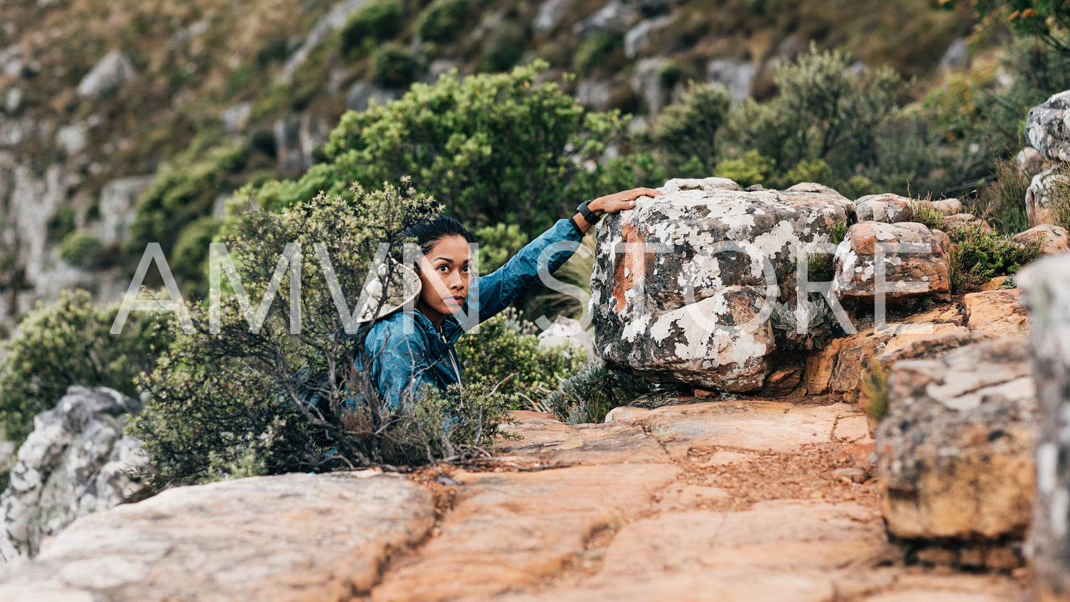 Woman grabs a stone, climbing up and looking away