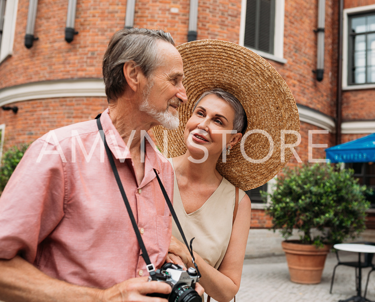 Aged smiling woman looking at her husband while their walk in the city