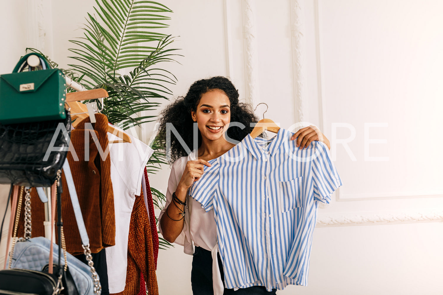 Young woman holding a hanger with a shirt	