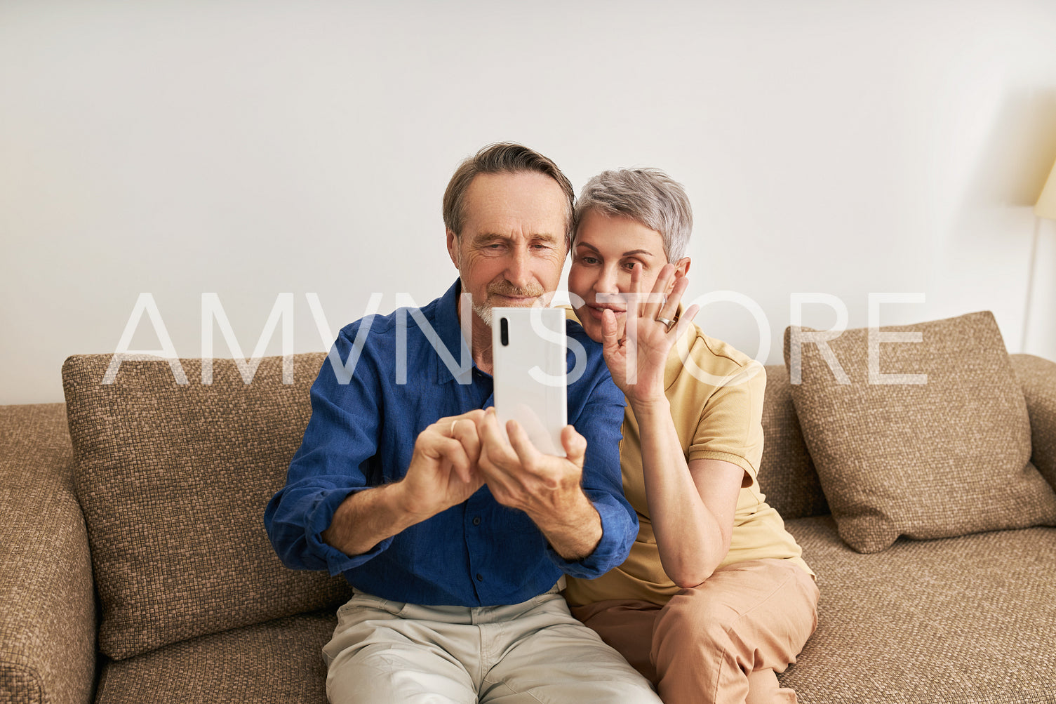 Senior couple making video call while sitting on a sofa in living room	