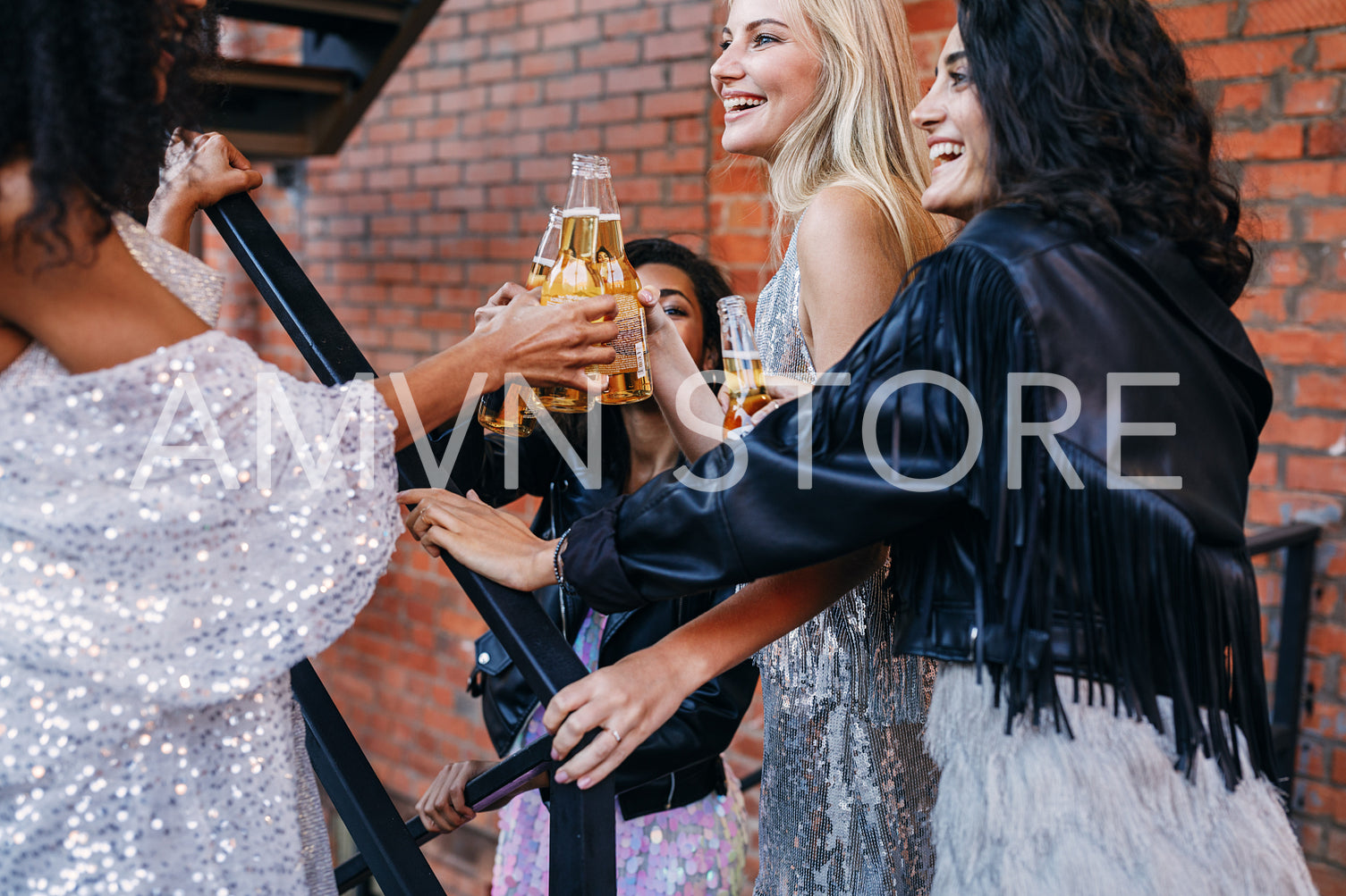 Group of women having drinks together. Female friends toasting with beer bottles while walking in the city.	