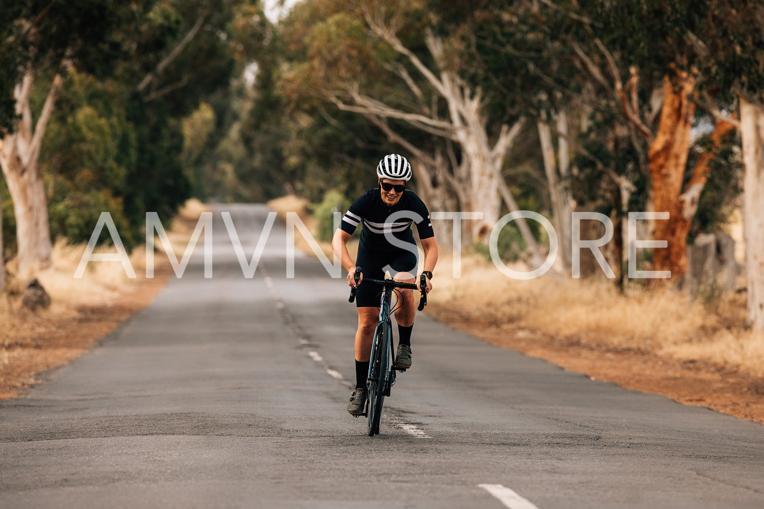 Young woman in sportswear on road bike doing intense training on empty countryside road