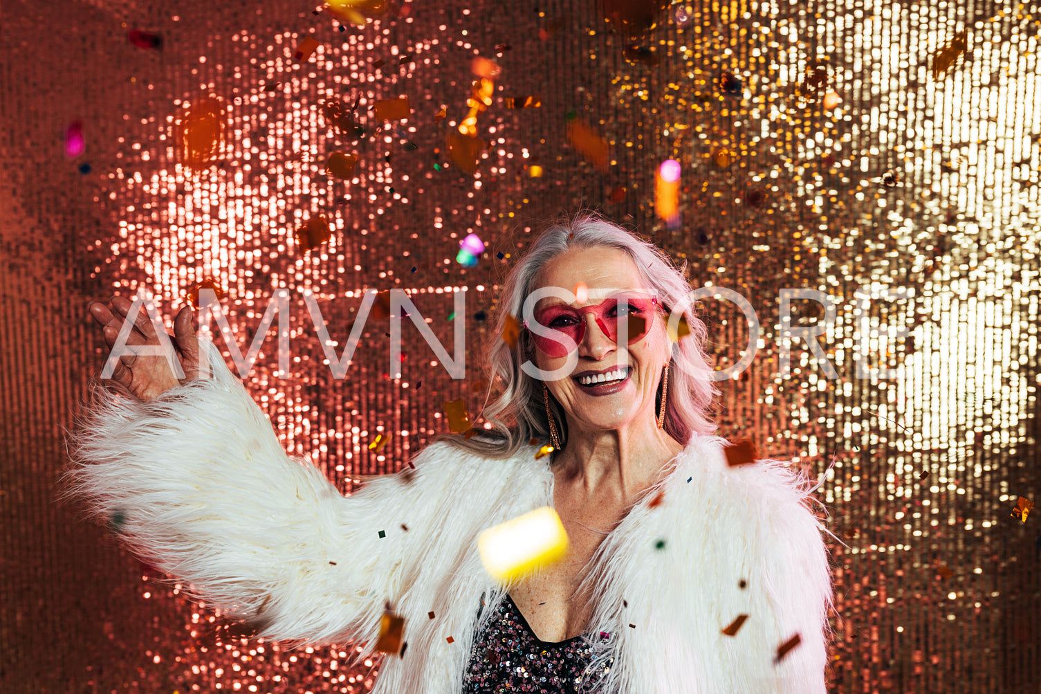 Happy senior woman in pink eyeglasses and white fur coat having 