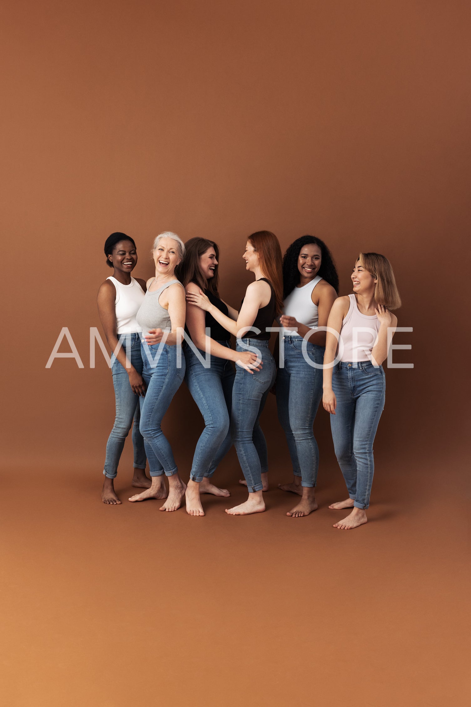 Six laughing women in casual dancing and having fun against brown background