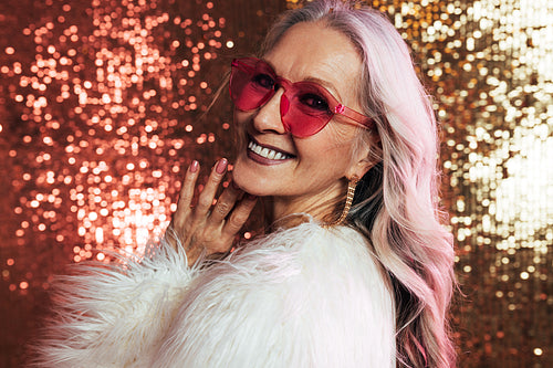 Portrait of a smiling senior woman with grey hair wearing pink e