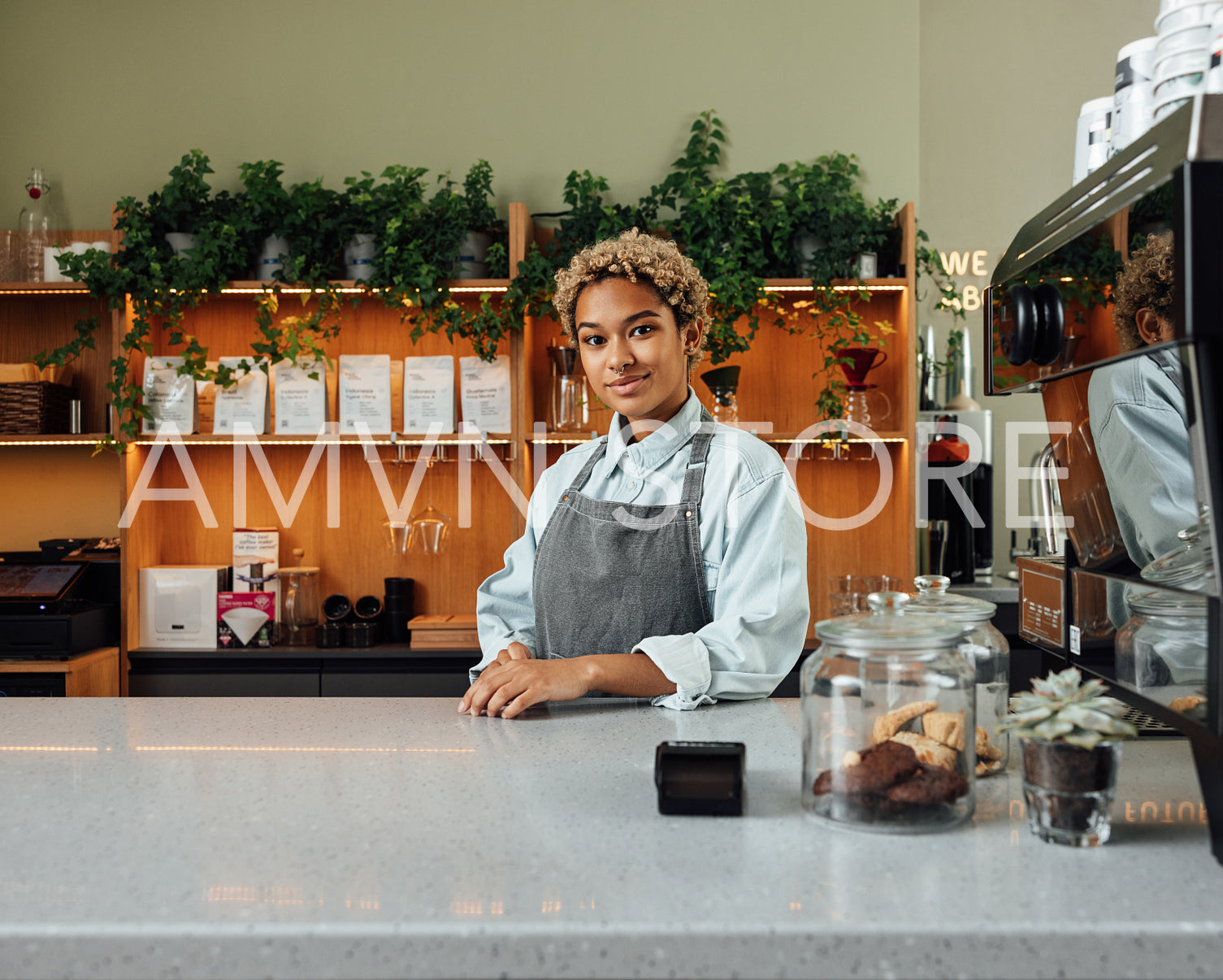 Portrait of a young and confident coffee shop owner at the counter looking at camera