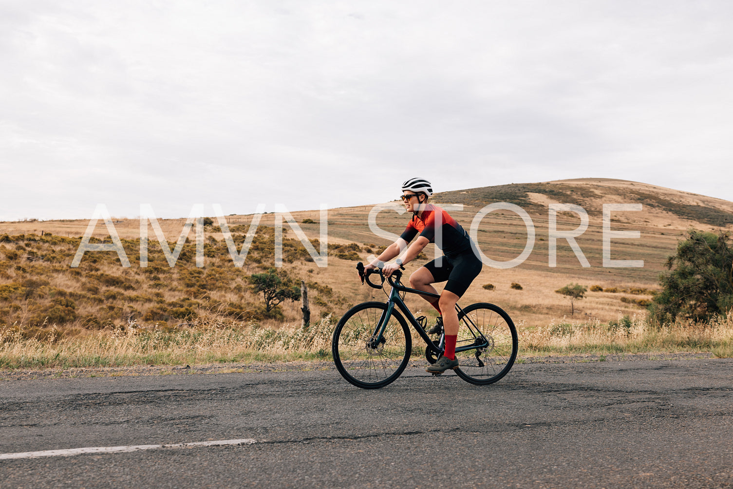 Side view of professional cyclist practicing on a countryside ro