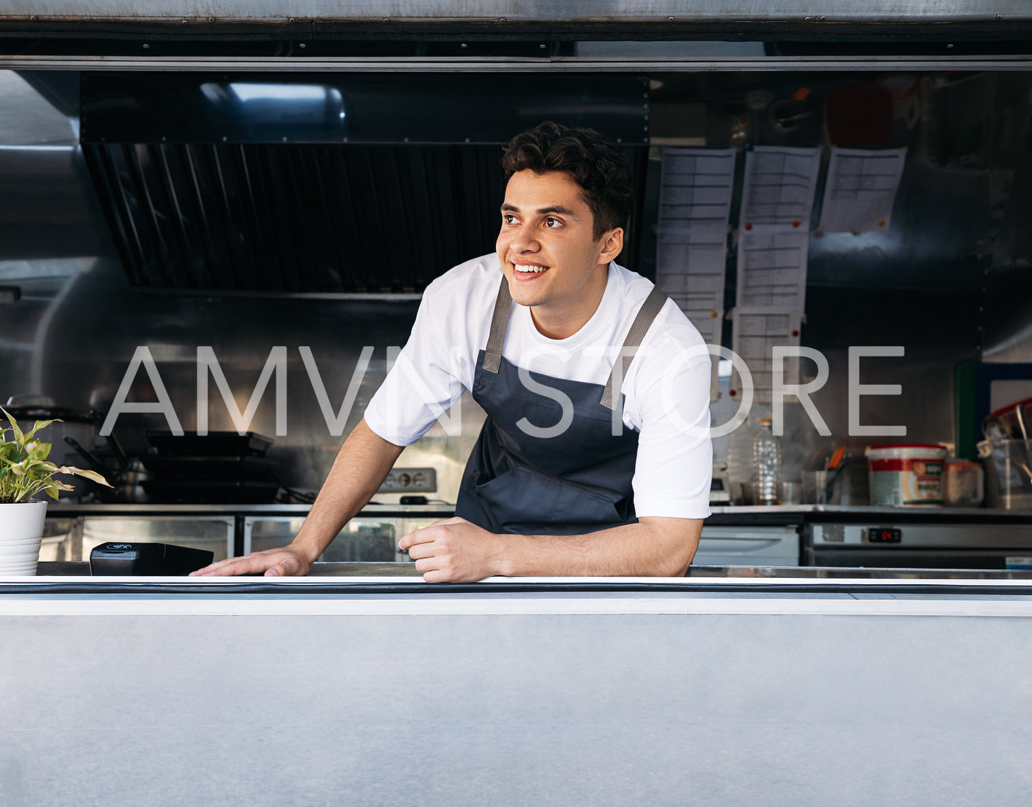 Portrait of a food truck owner. Young man working as a cook in a food truck.