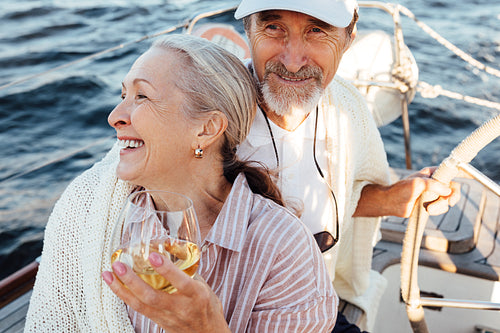 Woman on yacht uses a hat to hide her face from the sun