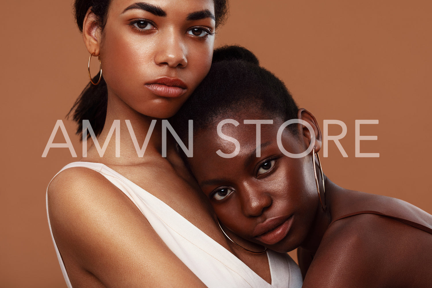 Two beautiful women standing in studio and looking at camera. Young woman relaxing on girlfriend's chest.	