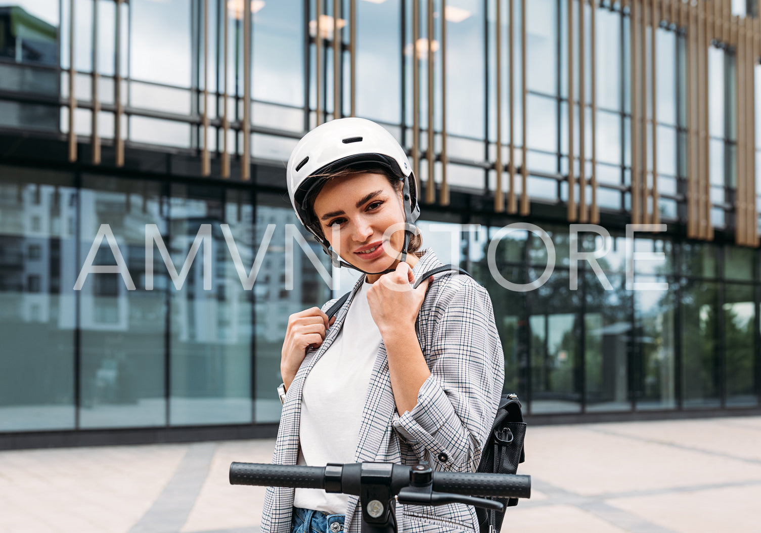 Beautiful caucasian woman in white cycling helmet posing outdoors and looking at camera