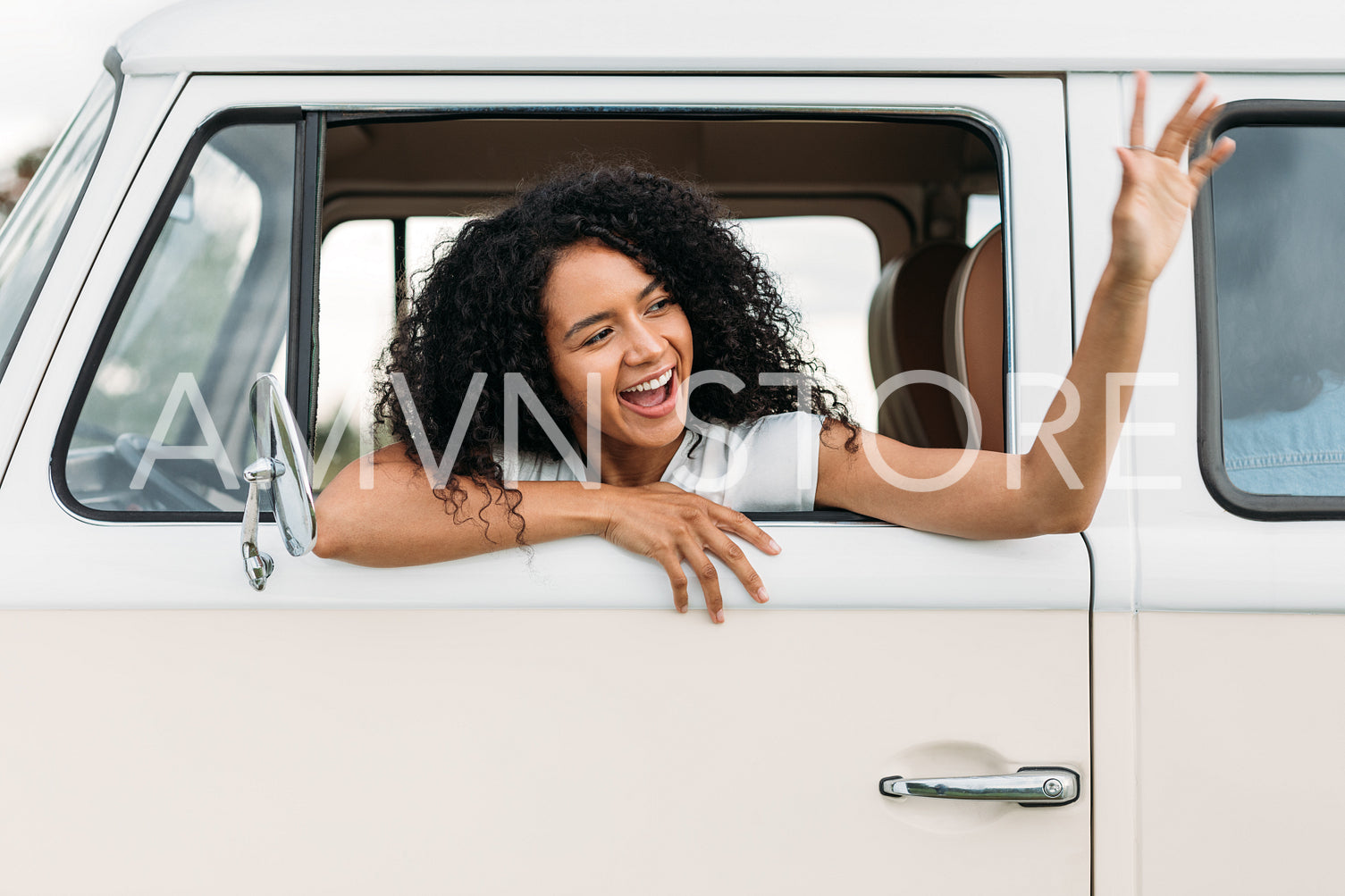 Female looking out from the van window with her arm waving