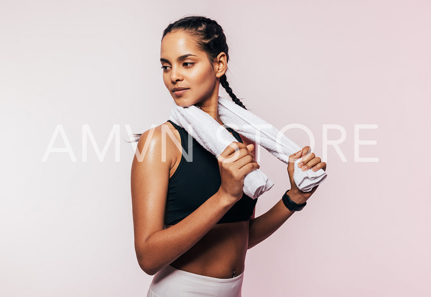 Portrait of a sportswoman with braids holding a white towel looking away	