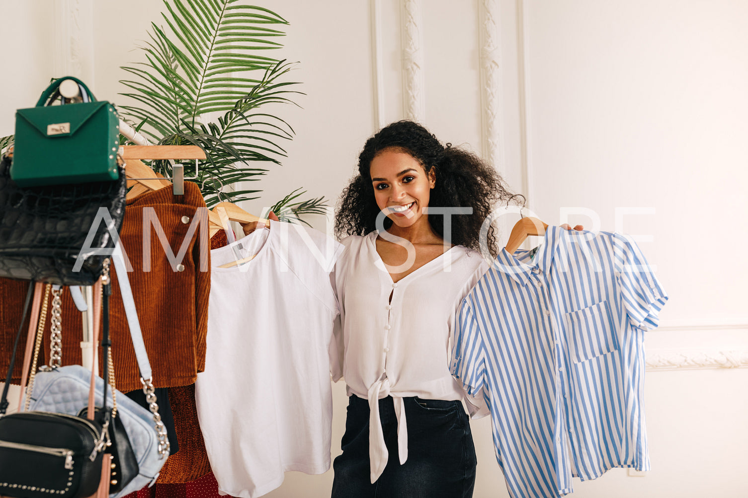 Young stylist choose clothes at rack in studio	