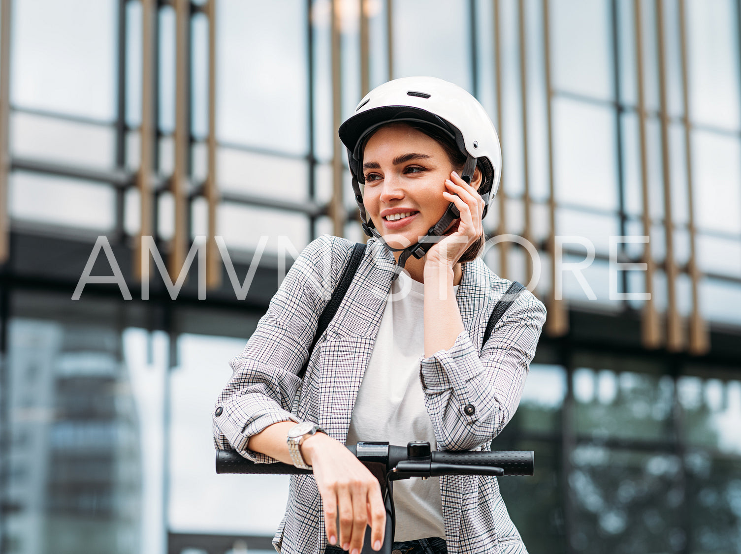 Beautiful caucasian woman in white helmet leaning on a handlebar of electric push scooter looking away