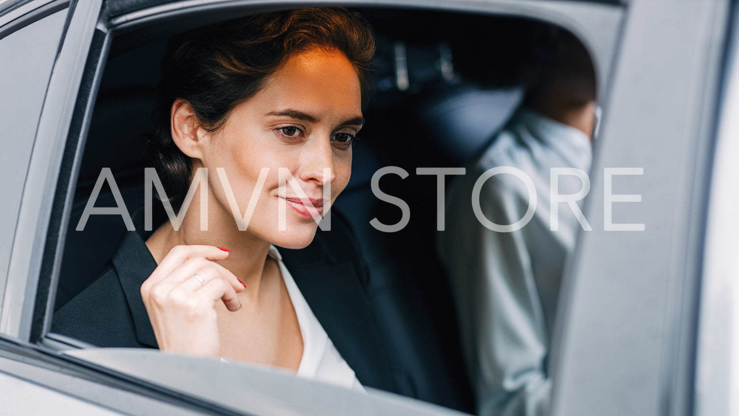 Beautiful businesswoman looking out of the window of a taxi. Young woman traveling by car.	