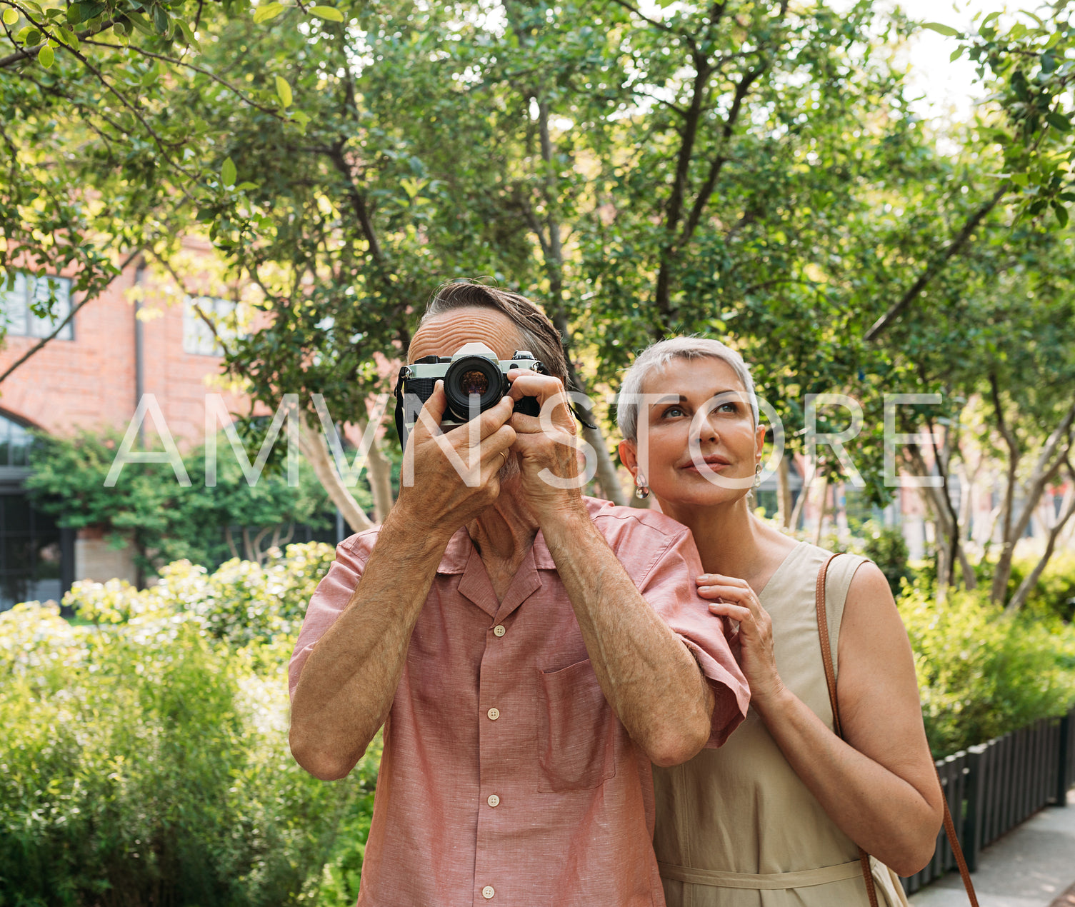 Mature couple taking photos while walking in the park