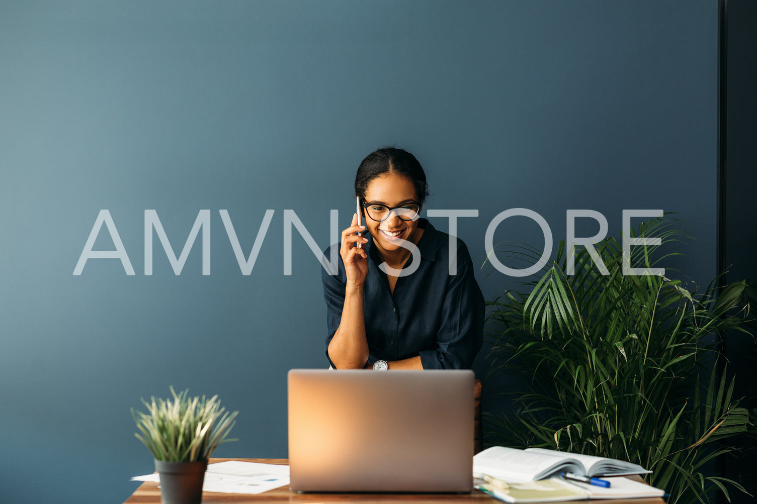 Young businesswoman standing leaning to a chair in living room while talking on cell phone	