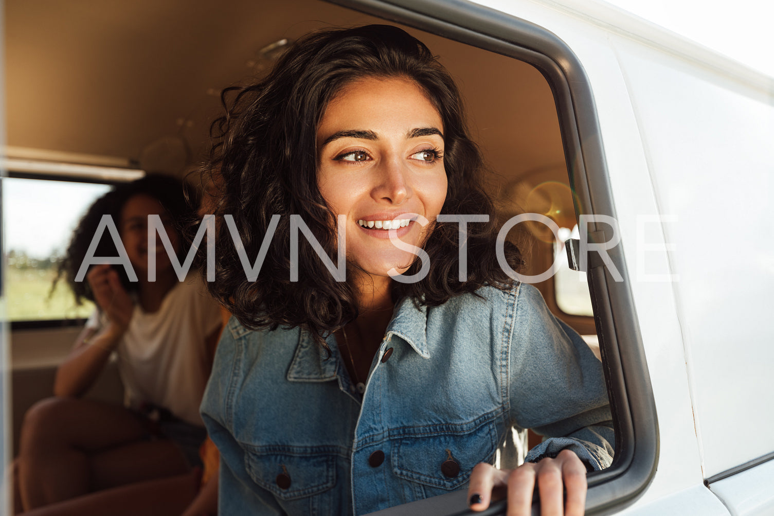 Beautiful brunette woman sitting in camper van looking out of window