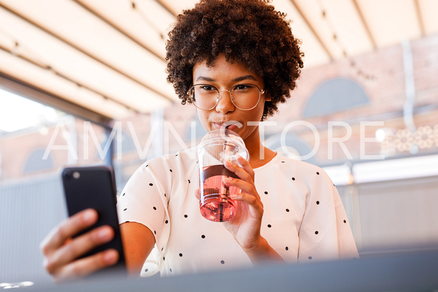 Young blogger wearing eyeglasses and taking selfie while drinking juice	