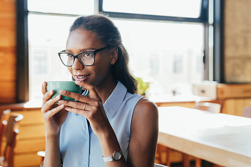 Beautiful woman sitting at cafe drinking coffee