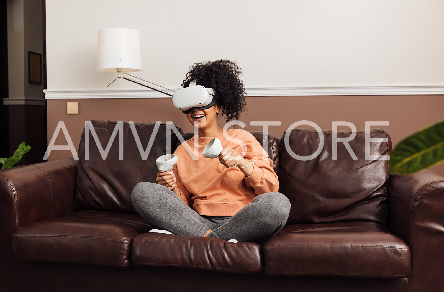 Cheerful woman wearing VR glasses holding joysticks