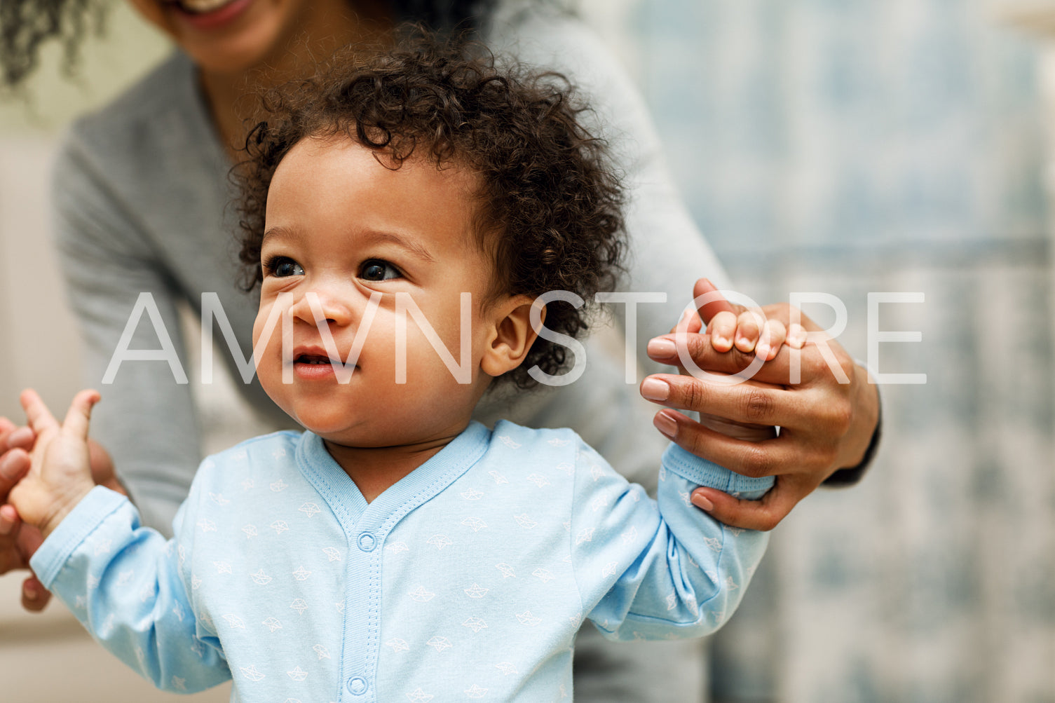 Mixed race mother playing with baby son in living room	