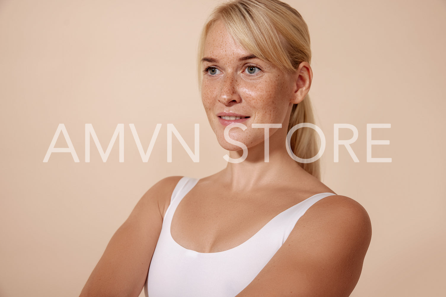 Studio portrait of a confident woman with freckles over pastel b