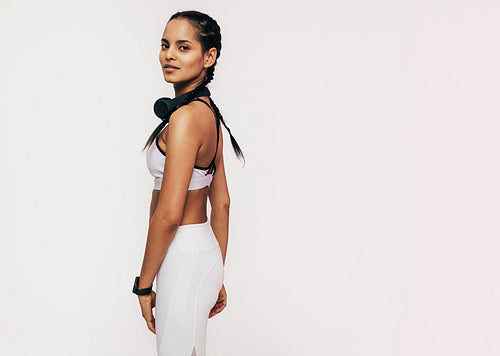 Beautiful mixed race woman in sportswear looking at the camera in a studio